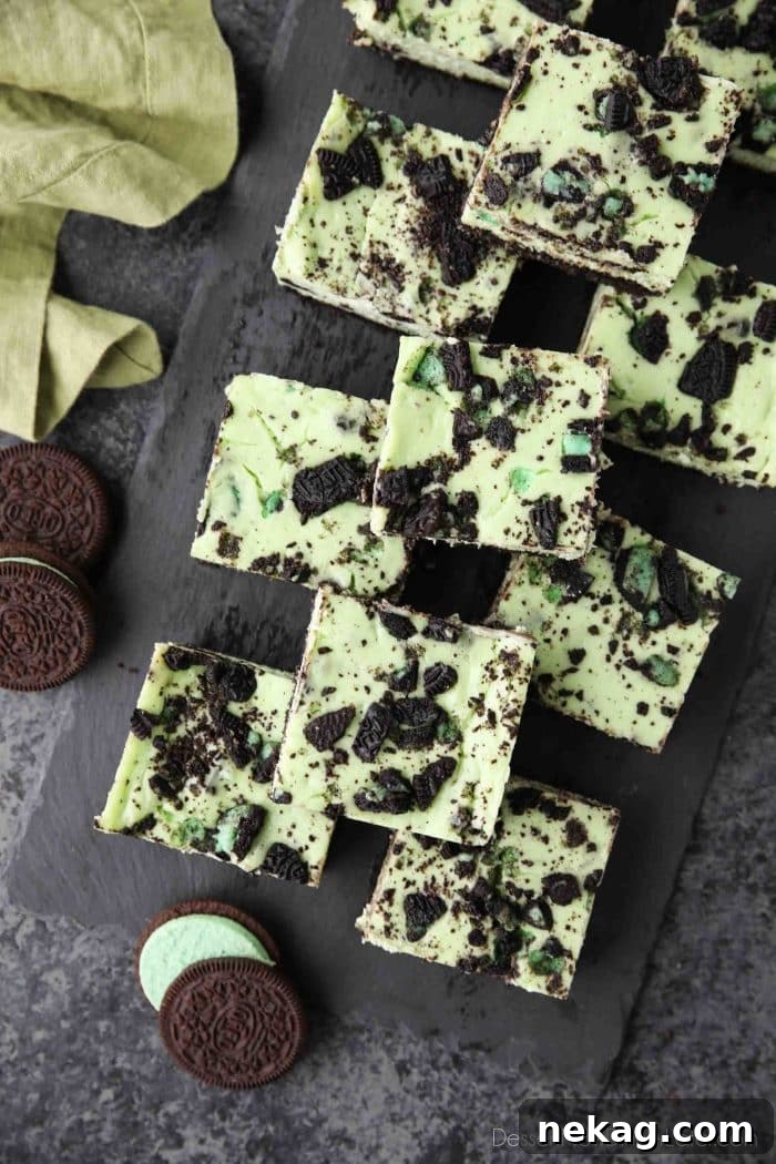 Mint Cookies and Cream Cheesecake Bars 3 Overhead view of a tray of Mint Oreo Cheesecake Bars with a spoon ready to serve.