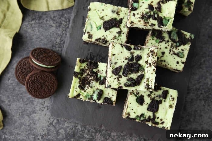 Mint Cookies and Cream Cheesecake Bars 4 A slice of Mint Oreo Cheesecake Bar showing the distinct layers of crust, cheesecake, and Oreo chunks.
