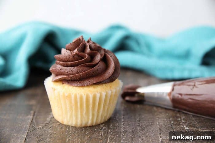 A vibrant yellow cupcake adorned with a generous swirl of rich chocolate frosting.