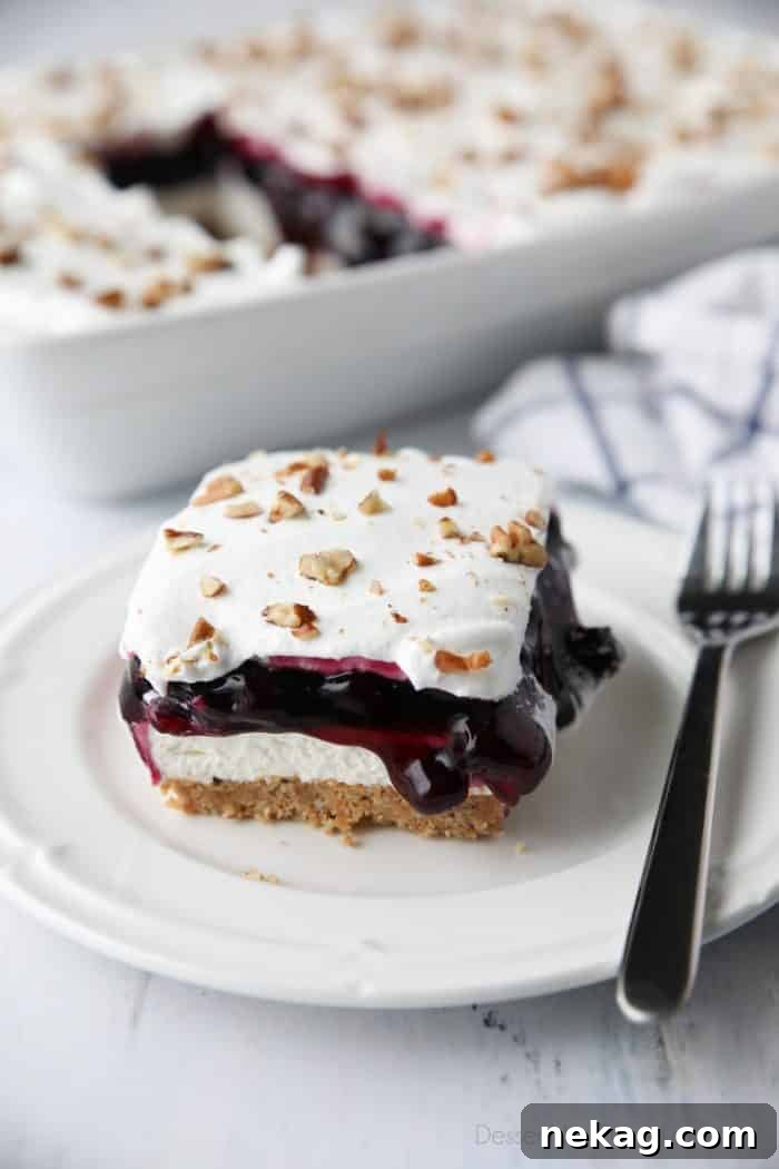 Blueberry Delight (aka Blueberry Lush) is an easy layered dessert with a graham cracker and pecan crust, no bake cheesecake, blueberry pie filling, and cool whip topping. A light, fruity, and delicious summer dessert with minimal baking.