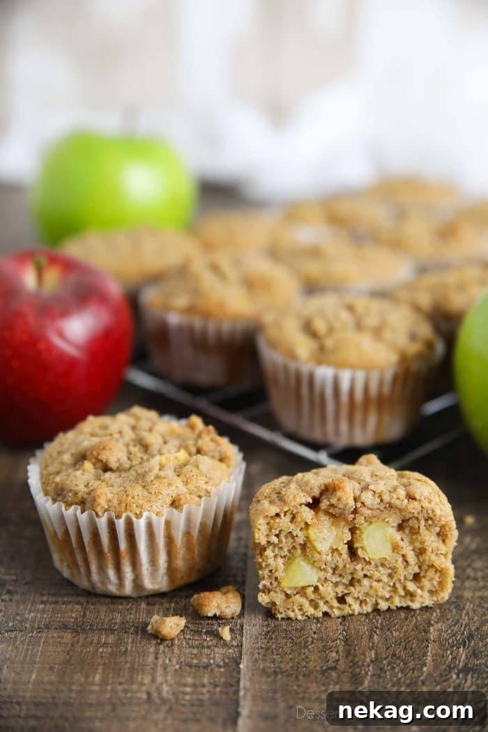 Fluffy Apple Cinnamon Muffins generously studded with fresh apple pieces and topped with a golden streusel crumb, invitingly placed on a cooling rack.