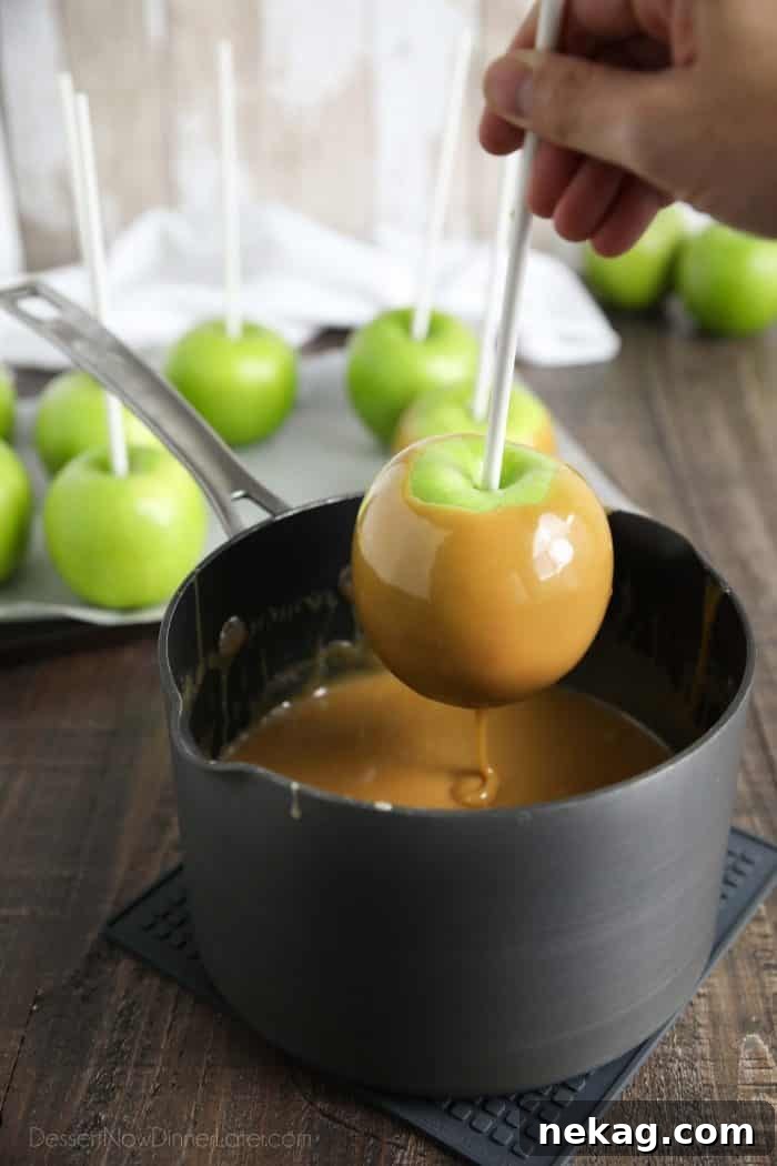 Handcrafted Caramel Apple Delights 7 Dipping a Granny Smith apple into easy homemade caramel.