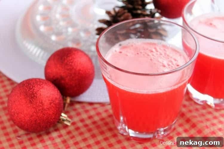Glasses of Crimson Christmas Punch served on a festive table with holiday decorations.