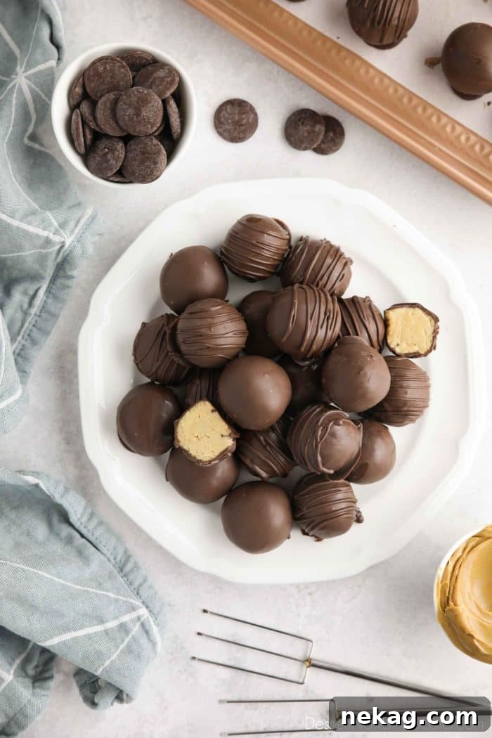No-Bake Peanut Butter Truffles 2 Easy Peanut Butter Balls stacked on a plate. Some drizzled, some plain, and two halves showing the peanut butter interior.