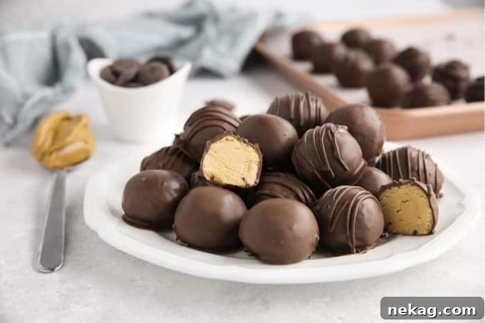 No-Bake Peanut Butter Truffles 11 Easy peanut butter balls stacked on a plate focusing in on one that has been cut in half to show the inside.