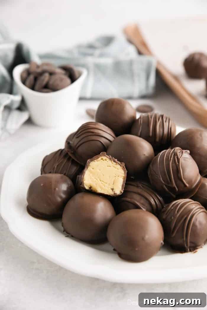No-Bake Peanut Butter Truffles 3 Easy peanut butter balls stacked on a plate focusing in on one that has been cut in half to show the inside.