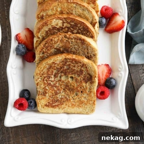 Ultimate Cinnamon French Toast Tutorial 12 Plate of cinnamon french toast with fruit and syrup on the side.