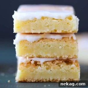 Three lemon blondies with glaze arranged for a featured shot.