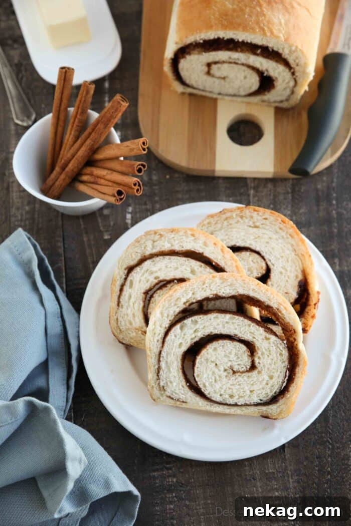 Effortless Cinnamon Swirl Delight 3 Plated slices of cinnamon swirl bread with the remaining loaf and a knife blurred in the background, highlighting the golden crust and internal swirl.