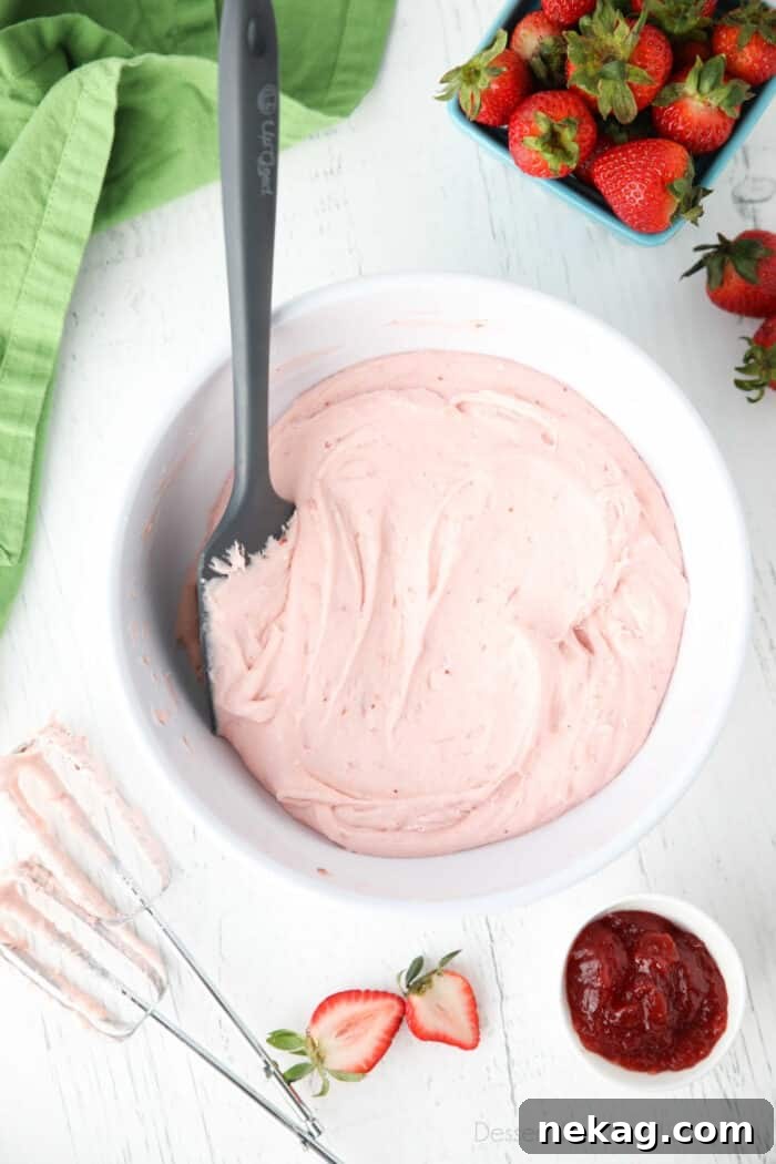 Strawberry buttercream frosting made with jam in a bowl.