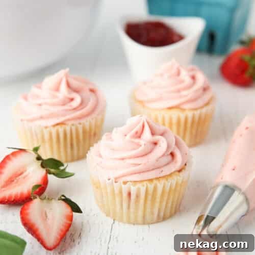 Strawberry frosting piped onto cupcakes.