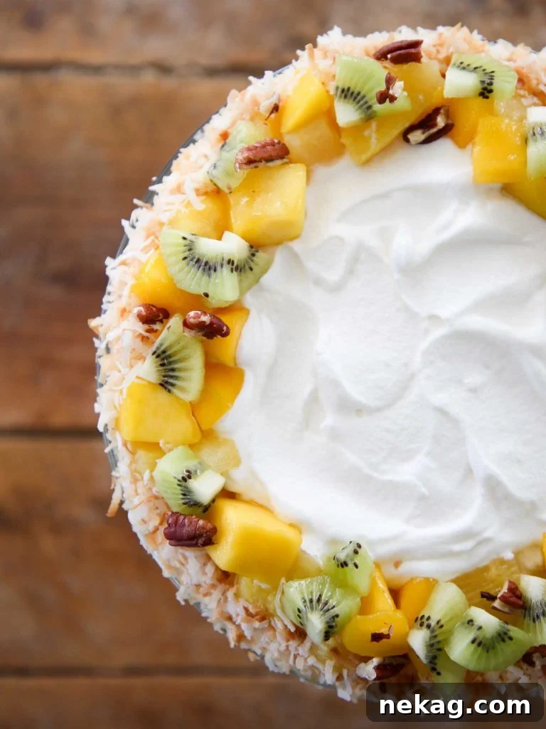 Tropical Trifle Recipe beautifully presented on a wood slate, adorned with fresh fruit.