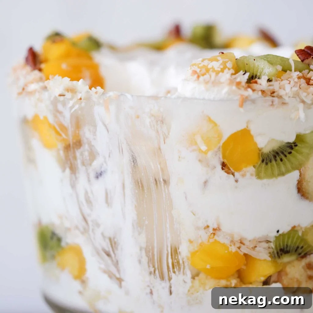 Close-up view of the interior layers of a Tropical Trifle, showing cake, fruit, and cream.