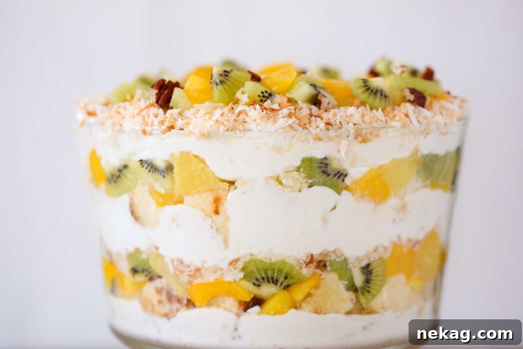 Tropical Trifle Dessert with tropical fruit and coconut flakes on a white background.