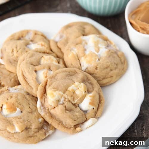 Delicious Fluffernutter Cookies 8 Fluffernutter cookies on a plate with bowls of mini marshmallows and peanut butter in the background.