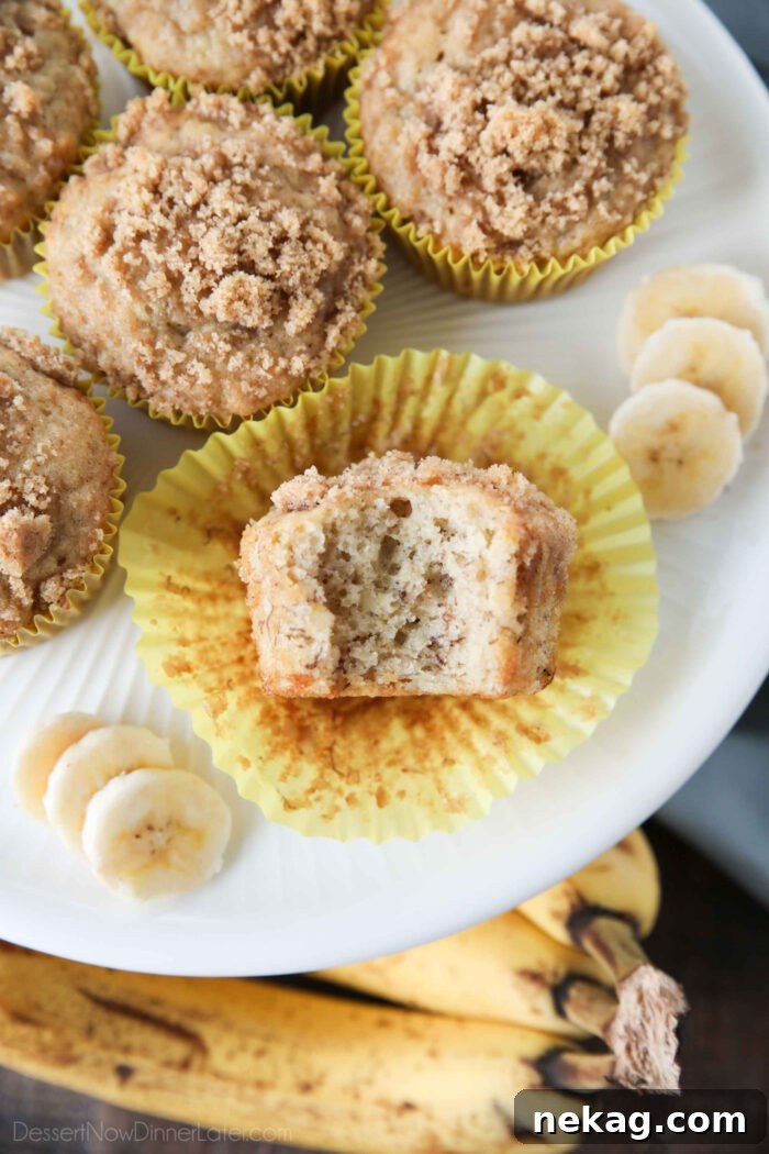 Golden Banana Streusel Muffins 3 Close up of a banana crumb muffin with a bite taken out.