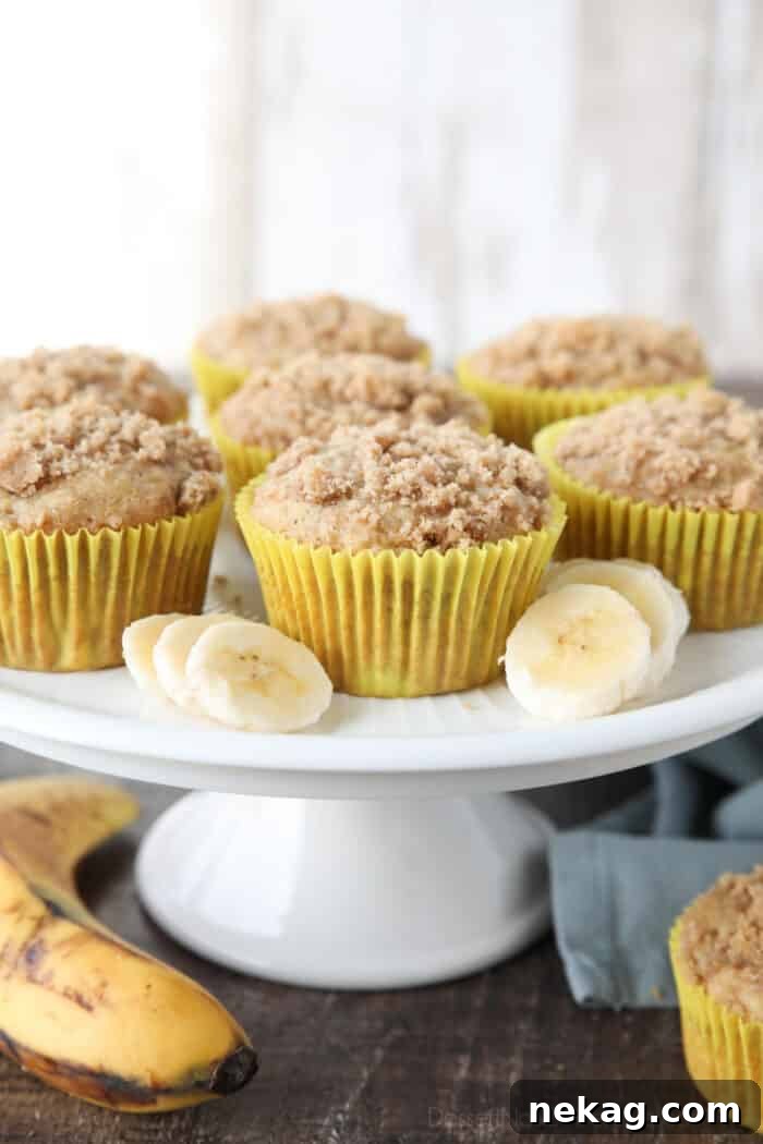 Golden Banana Streusel Muffins 4 Cake plate with banana crumb muffins and slices of bananas.