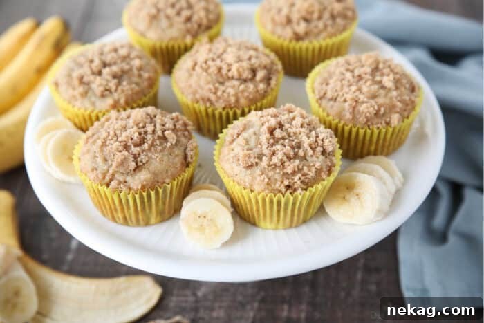 Golden Banana Streusel Muffins 5 Top view of banana crumb muffins and banana slices on a cake plate.