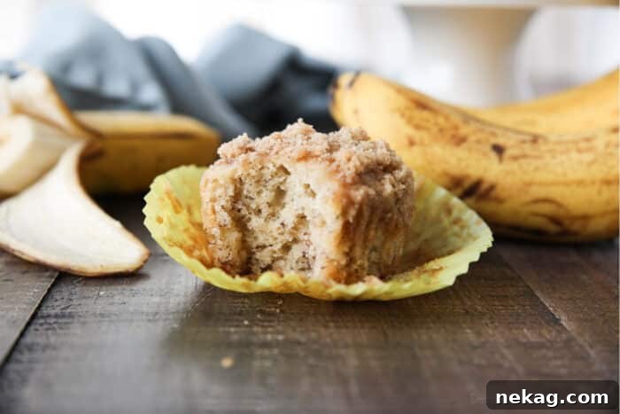 Golden Banana Streusel Muffins 6 Side view of a banana crumb muffin with a bite taken out.
