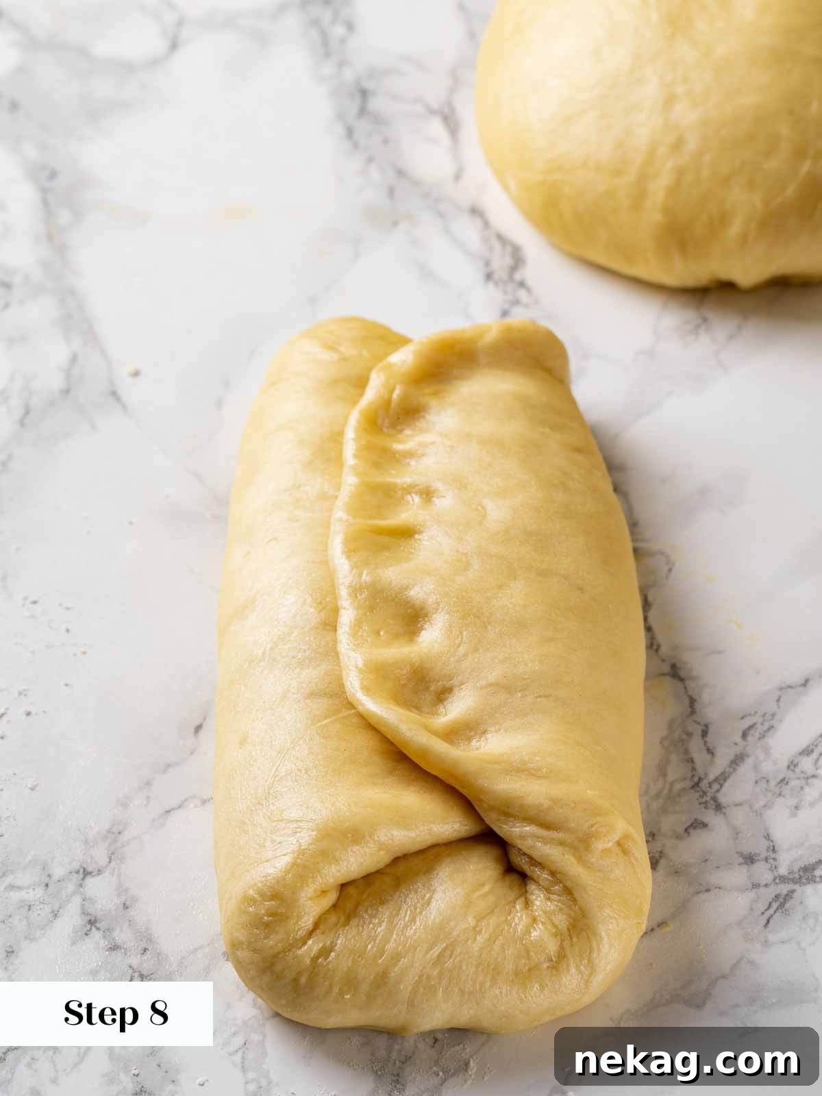 The final stage of shaping brioche dough, forming a taut, even log ready for the loaf pan.