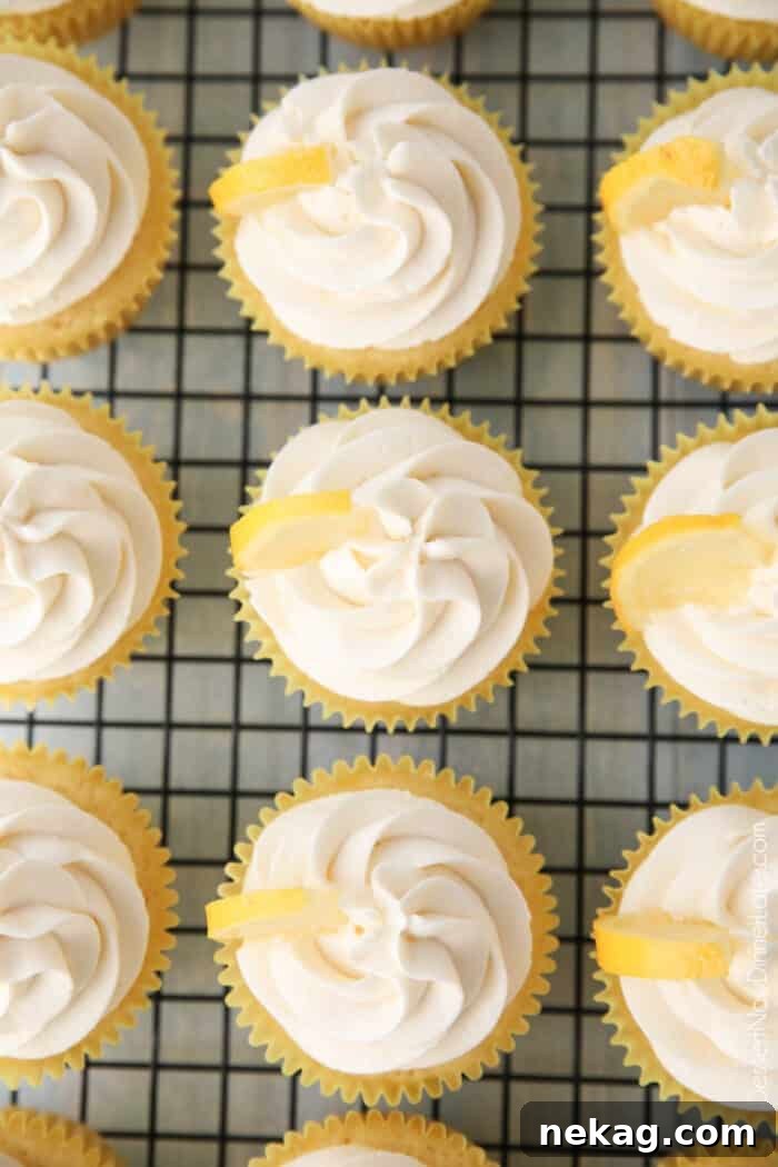 Zesty Lemon Cupcake Delight 4 Top view of cream cheese frosting and lemon wedges atop lemon cupcakes.