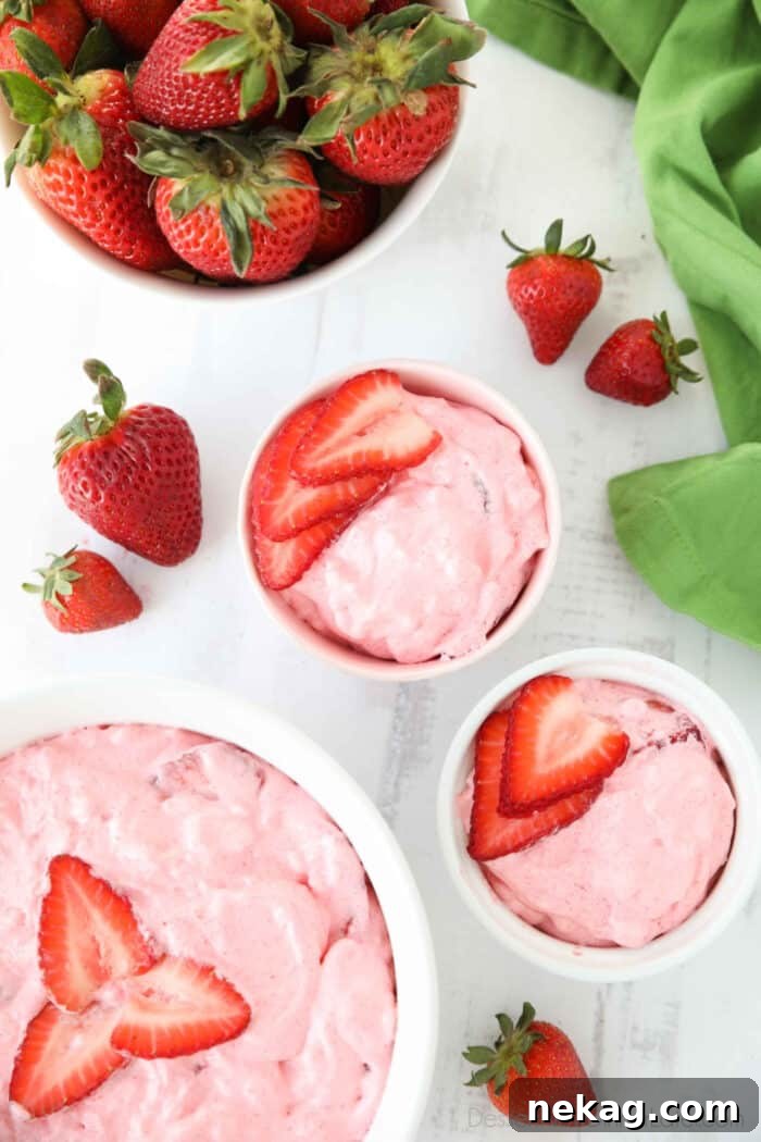 Top view of three bowls of strawberry fluff with sliced strawberries on top.