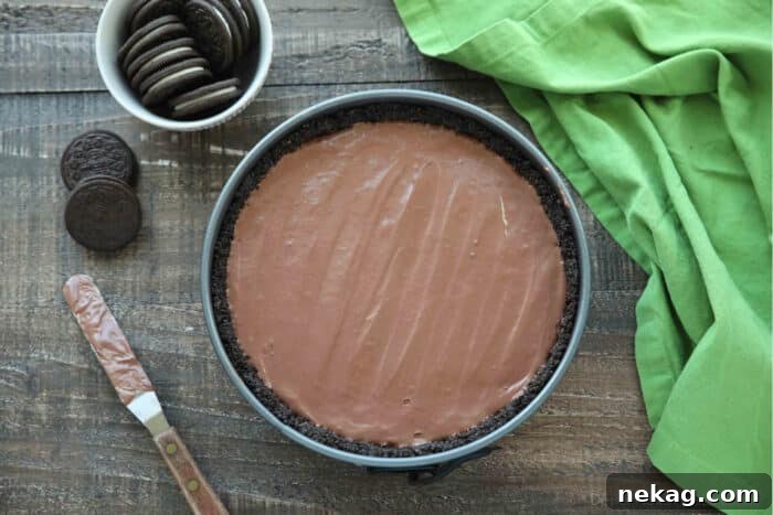 Effortless Chocolate Bliss 11 The chocolate cheesecake filling spread smoothly and evenly inside the Oreo crust within the springform pan, ready for chilling.