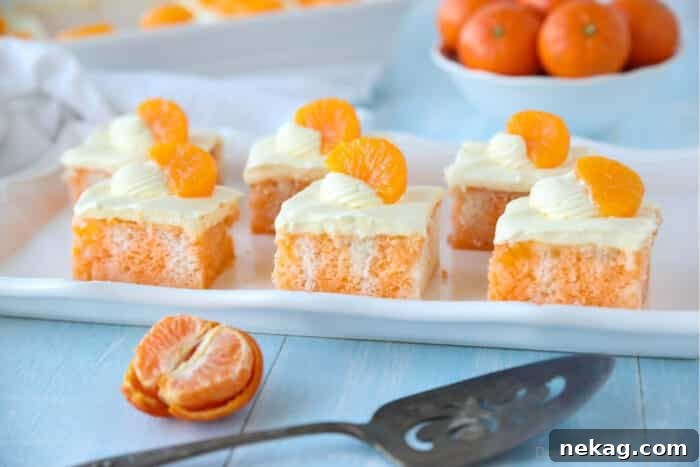 Orange Creamsicle Dream Cake 10 Beautifully plated slices of Orange Creamsicle Cake, each topped with vibrant mandarin orange segments, ready to be enjoyed.