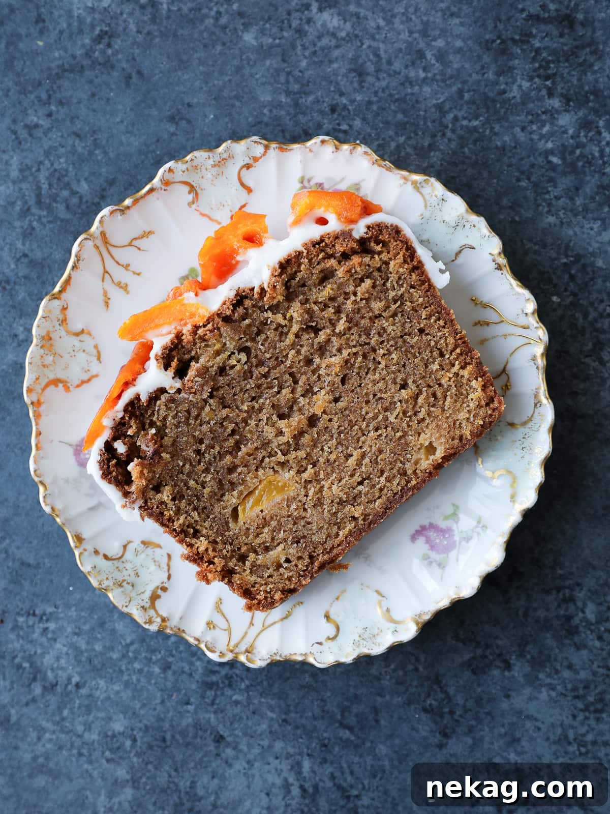 Sun-Kissed Peach Cake 2 Single slice of moist peach cake on a plate, showcasing its soft crumb, golden edges, and fresh peach pieces.