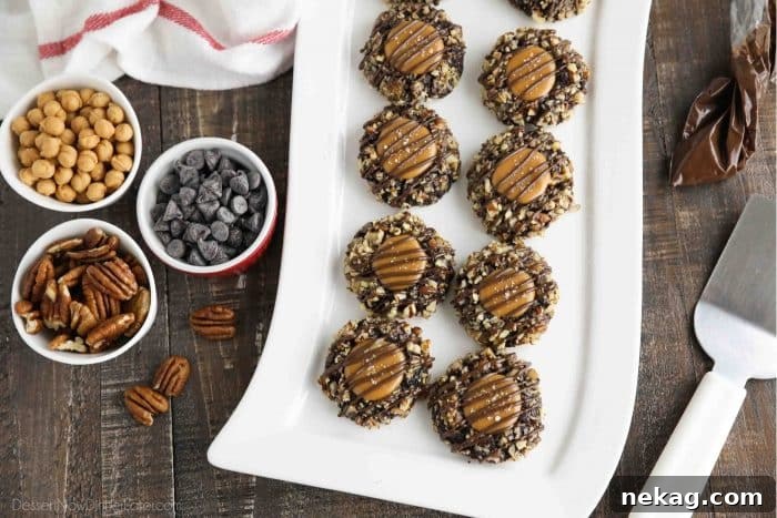 Delicious Turtle Thumbprint Cookies 5 A rectangular plate of finished Turtle Thumbprint Cookies, surrounded by bowls of pecans, caramel bits, and chocolate chips, ready for assembly, highlighting key ingredients.