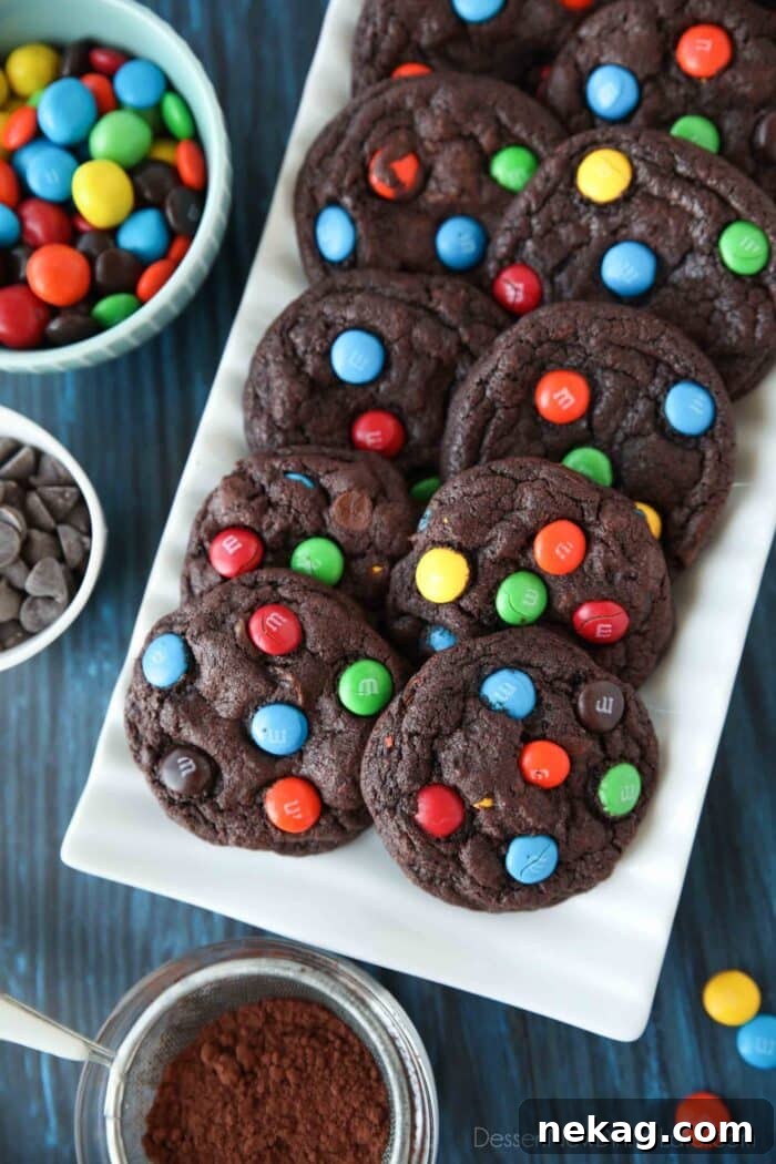 Colorful M and M Chocolate Cookies 4 A close-up shot of a serving platter showcasing several chocolate M&M cookies, revealing the melted chocolate chips and colorful M&M's baked into their soft, dark centers.