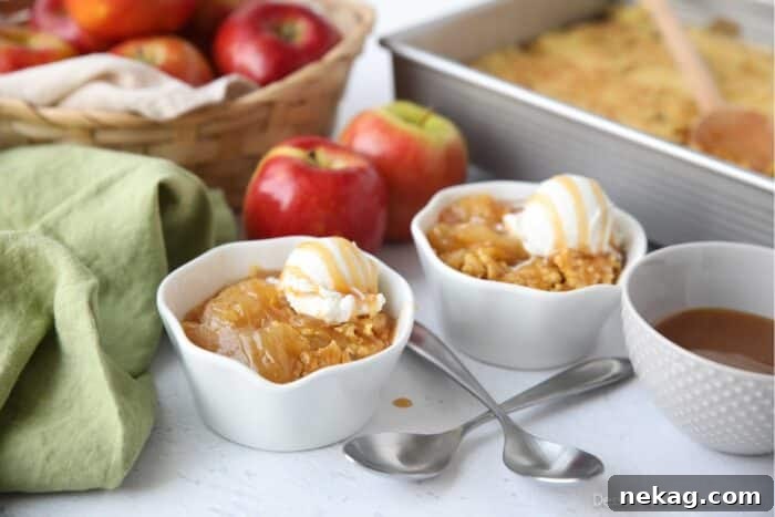 Multiple servings of caramel apple dump cake in small individual bowls, each topped with a scoop of vanilla ice cream and a caramel drizzle.