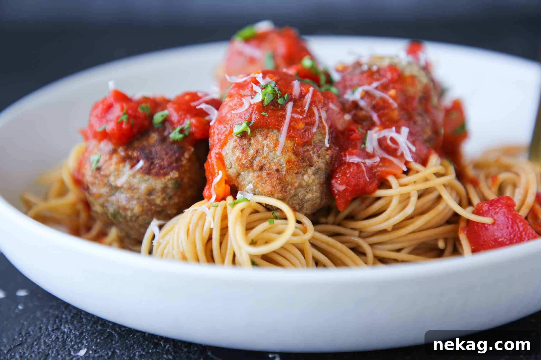 Golden Baked Turkey Meatballs 4 Baked turkey meatballs served in a white pasta dish, ready to eat.