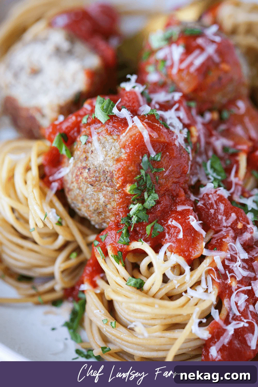Golden Baked Turkey Meatballs 7 Delicious baked turkey meatballs with pasta and sauce, close-up shot.