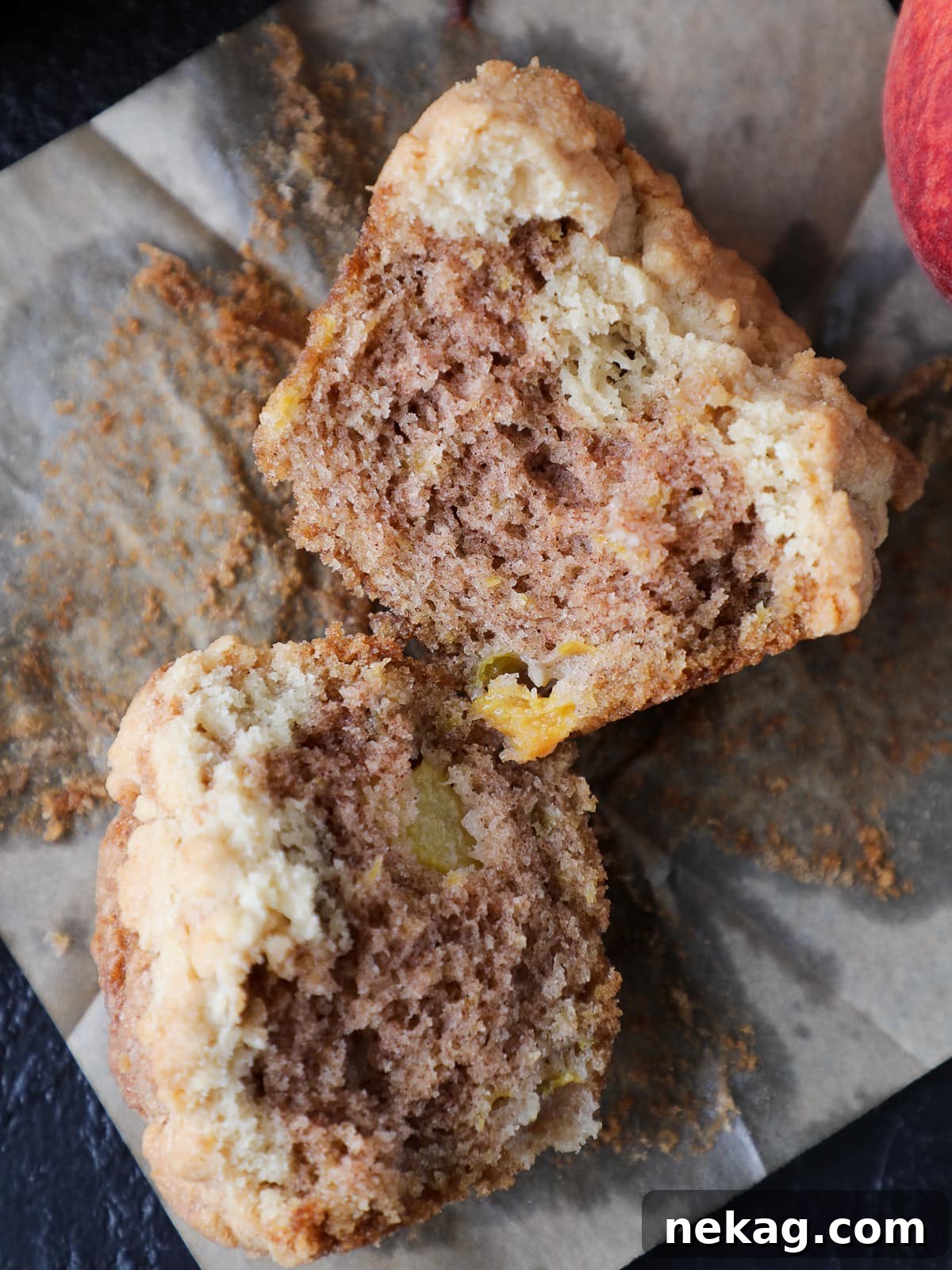 Golden Peach Muffins 2 Cut peach muffin with tender crumb and visible chunks of fruit baked into the center, highlighting its moist interior.