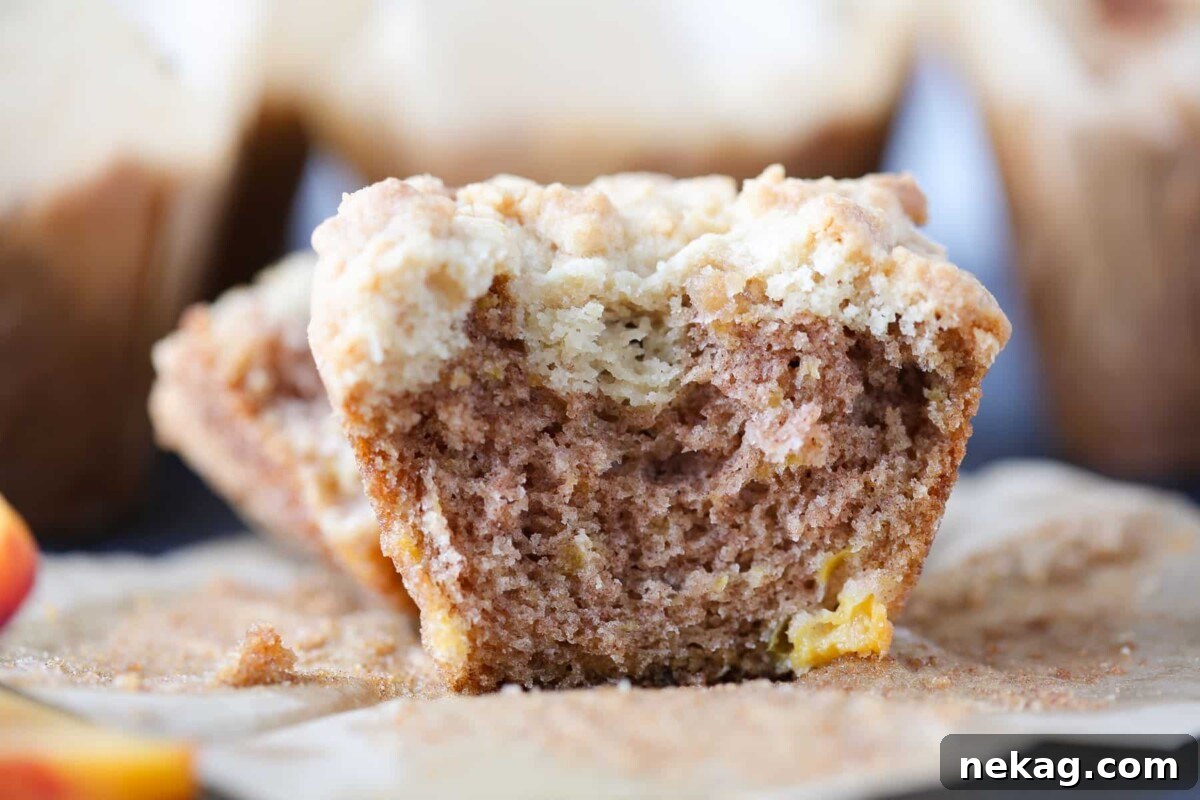 Golden Peach Muffins 3 Halved peach muffin showcasing a perfectly moist interior crumb and generous chunks of baked peach distributed throughout.
