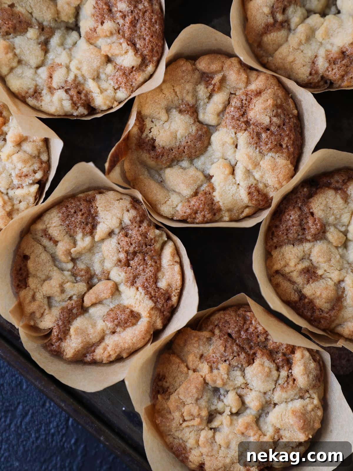 Golden Peach Muffins 4 Group of peach muffins cooling on a wire rack, featuring golden domed tops and warm fruit baked into each one.