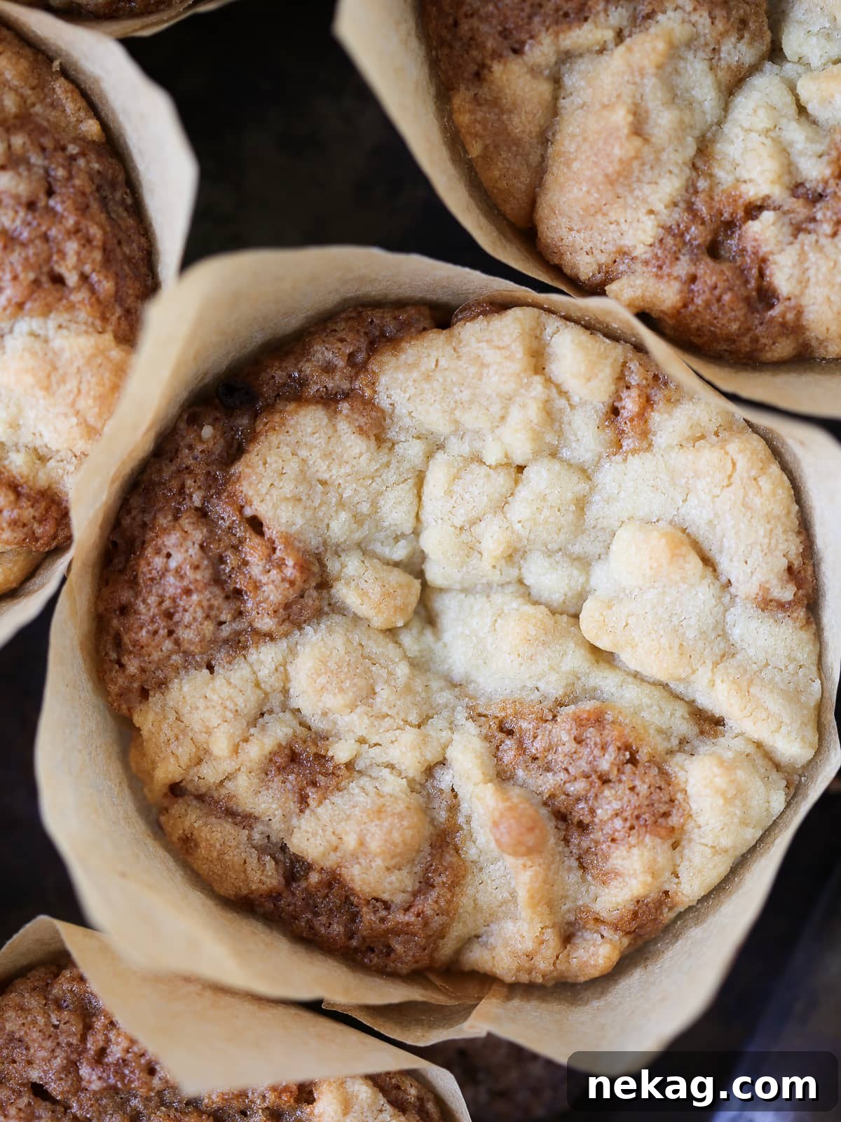 Golden Peach Muffins 5 A single peach muffin topped with a generous, crumbly brown sugar streusel and visible peach pieces within its golden crust.