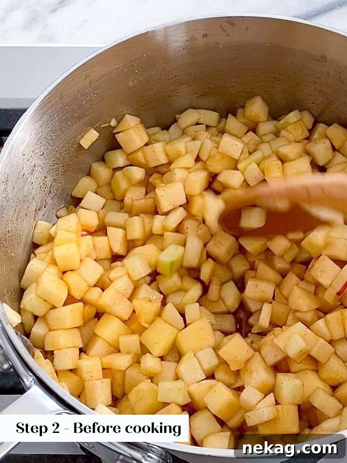 Cinnamon apple filling gently cooking in a pot on the stovetop, releasing aromatic steam.