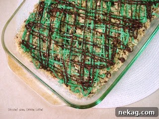 Close-up of a single mint chocolate krispie square with green and red sprinkles.