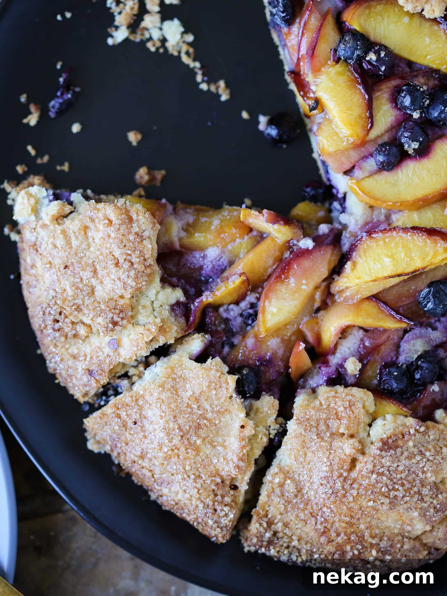 Sun-Kissed Blueberry Nectarine Galette 2 Sliced Blueberry Nectarine Galette with a flaky almond crust and juicy fruit filling.