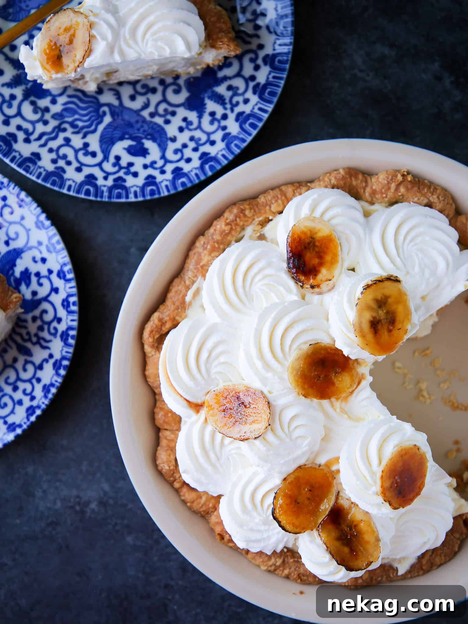 Golden Banana Delight 2 Banana Cream Pie sliced with vintage blue plates, showcasing its creamy layers.