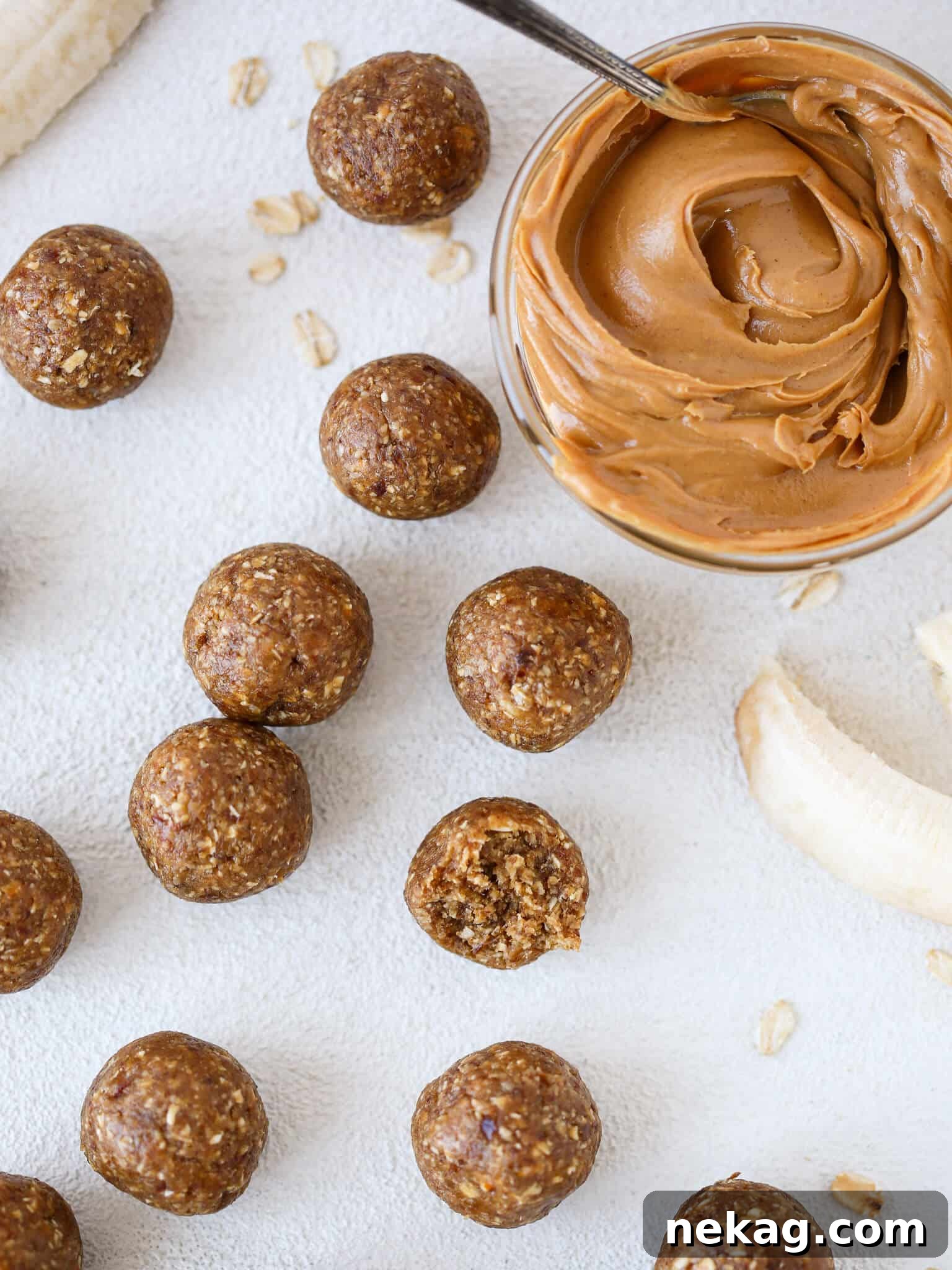 Peanut Butter Banana Fuel Bites 2 Overhead view of several Peanut Butter Banana Energy Bites, perfectly round and golden brown, arranged on a rustic wooden surface, highlighting their homemade appeal.
