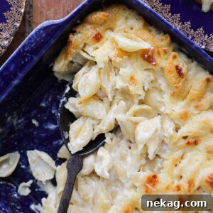 White cheddar mac and cheese perfectly baked with a little golden brown around the edges, showcasing its cheesy perfection.