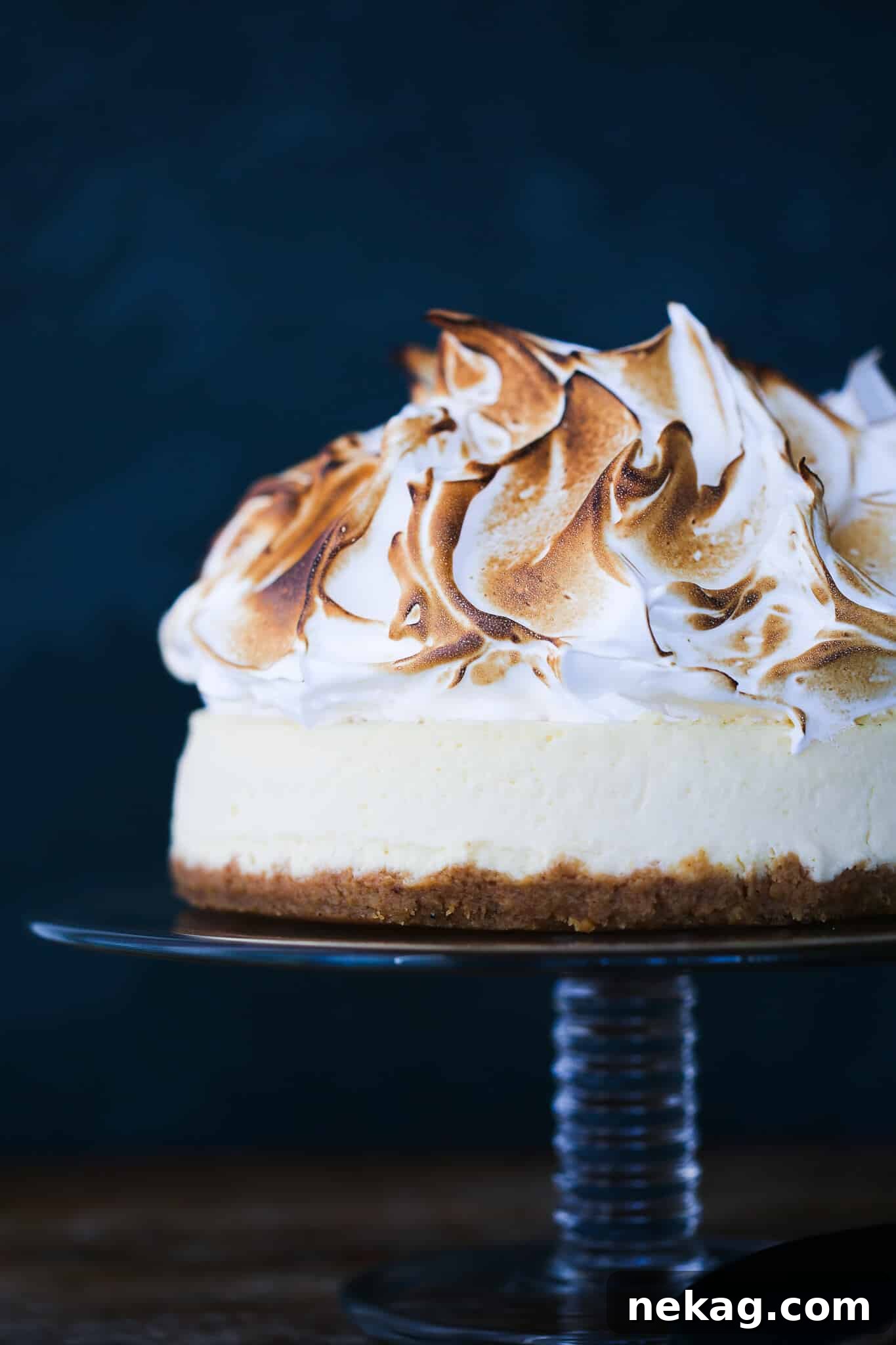 A stunning Lemon Meringue Cheesecake, unsliced, showcasing its towering marshmallow meringue, perfect for Valentine's Day or any special occasion.