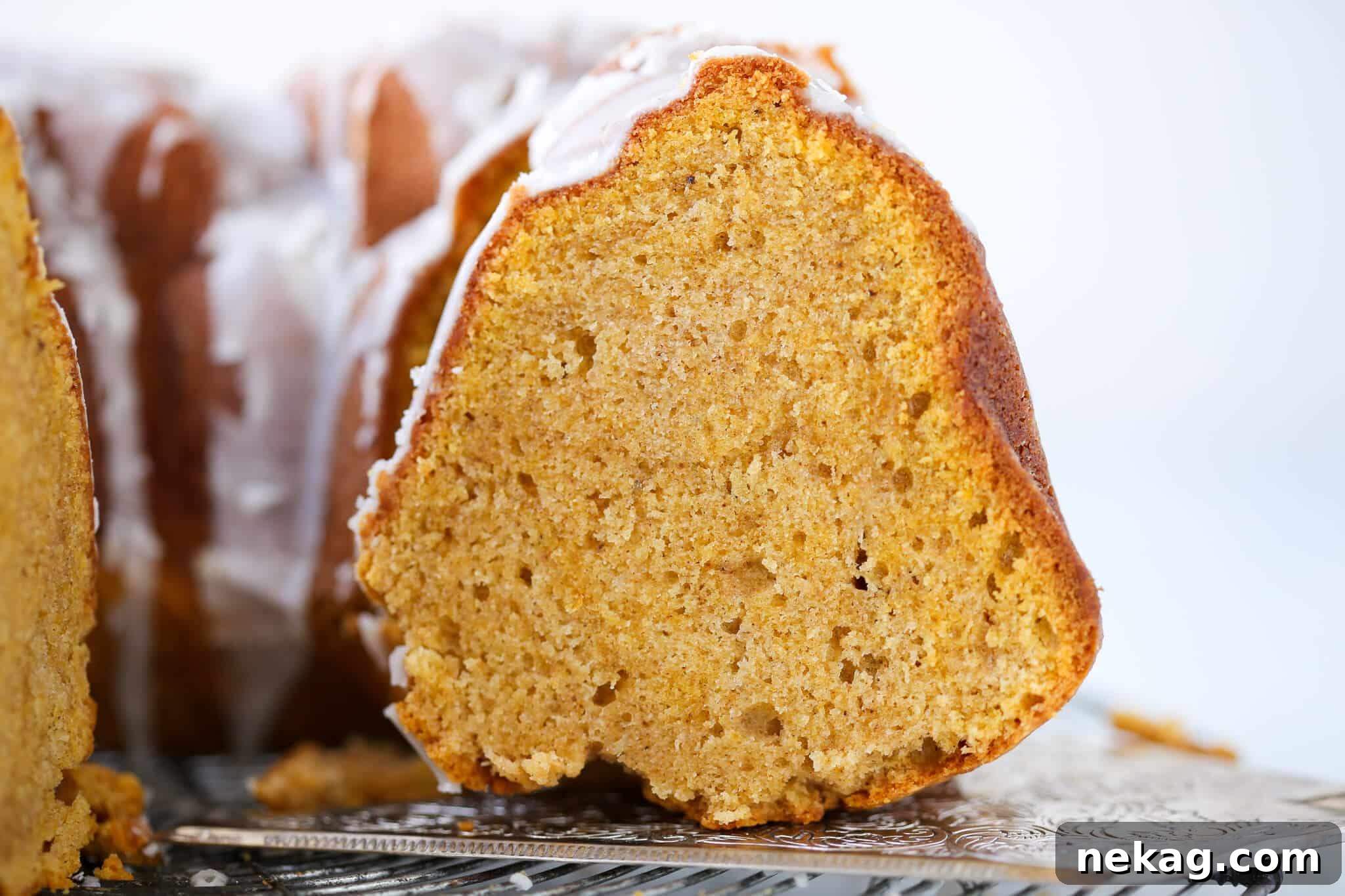 Pumpkin Harvest Bundt Bliss 5 A perfectly sliced pumpkin spice bundt cake, revealing its moist interior and intricate design, ready to be served as a delightful fall dessert.