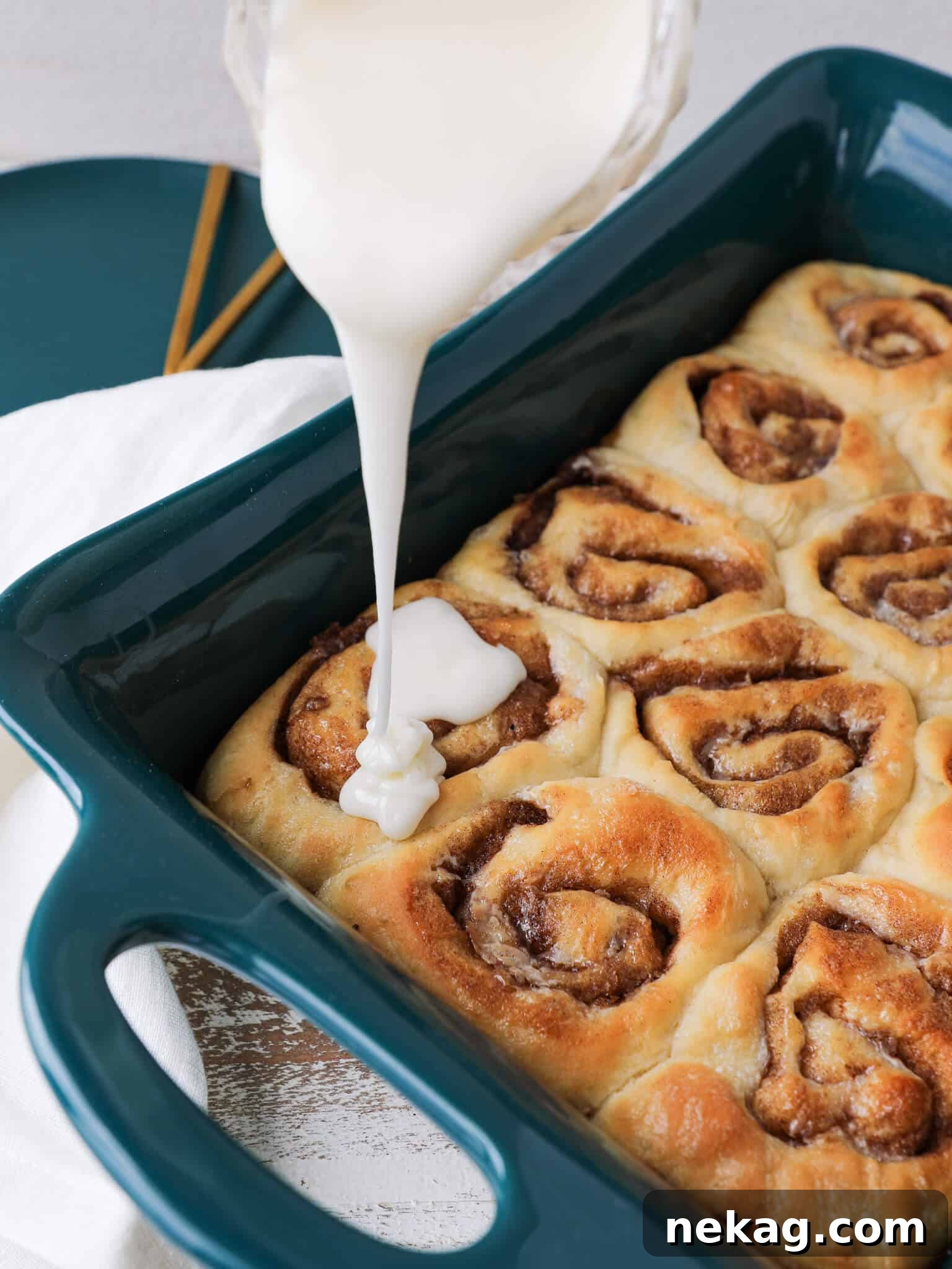 Irresistible Cream Cheese Cinnamon Rolls 2 The Best Homemade Cinnamon Rolls, freshly baked and glistening with cream cheese icing in a baking dish.