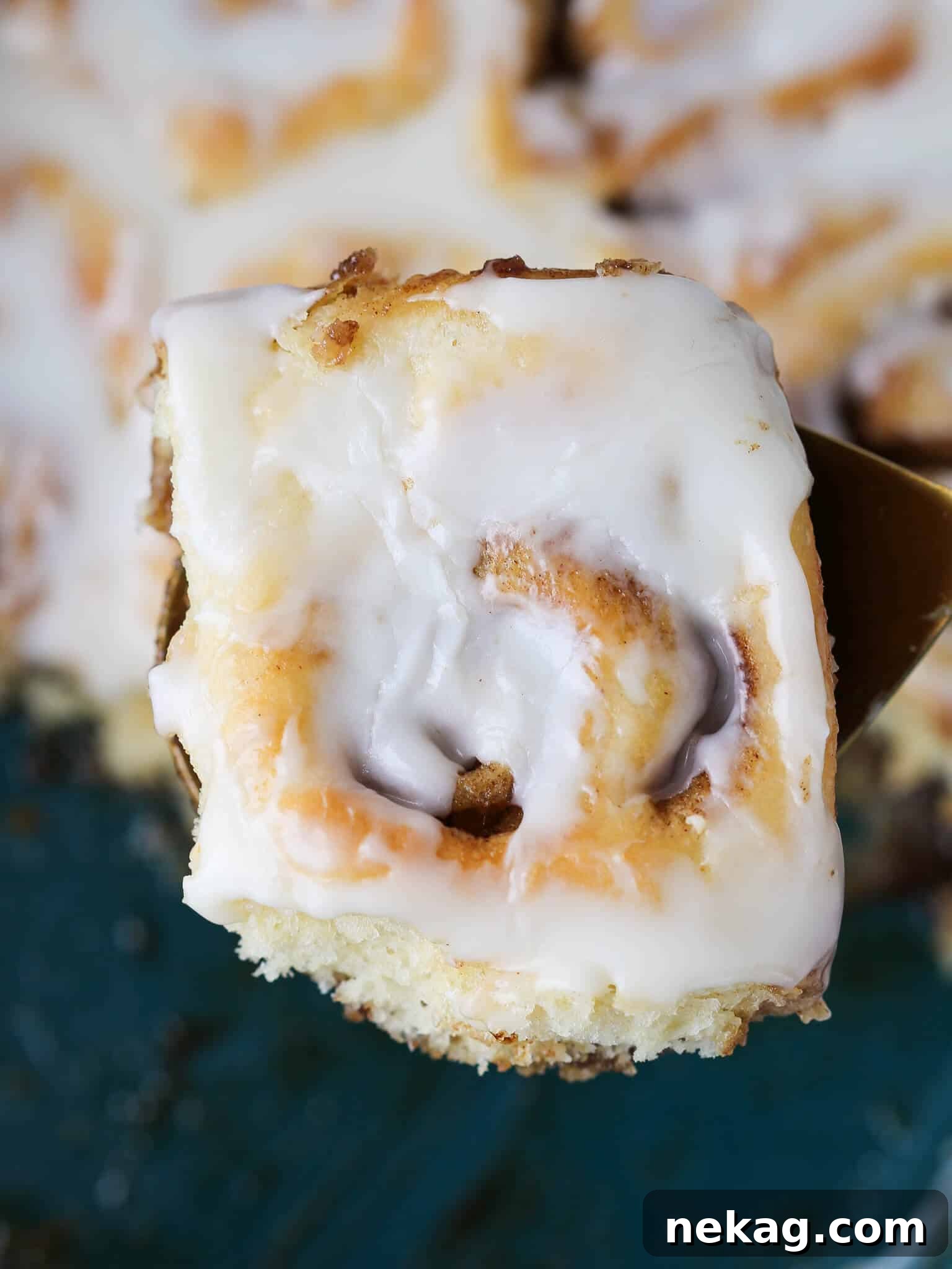 Irresistible Cream Cheese Cinnamon Rolls 5 A perfectly baked and iced cinnamon roll presented on a gold serving tray, showcasing its beautiful layers.