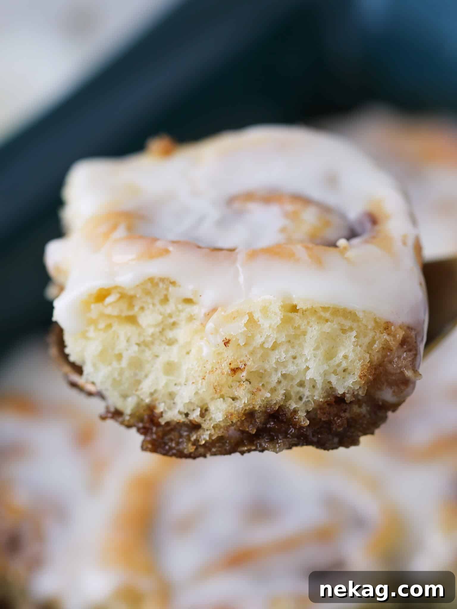 Irresistible Cream Cheese Cinnamon Rolls 6 Detailed side view of baked cinnamon rolls, showing their moist, spiraled layers and generous frosting.