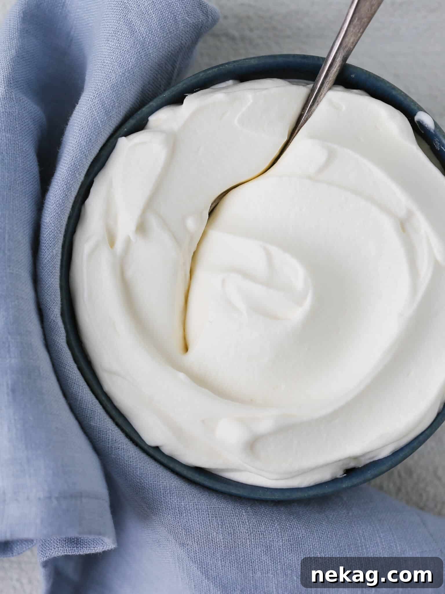 Silky Homemade Whip 2 Homemade whipped cream elegantly presented on a blue napkin, showcasing its creamy texture.